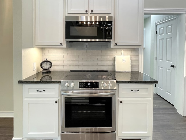 kitchen featuring wood finished floors, white cabinets, dark stone countertops, backsplash, and stainless steel electric range oven
