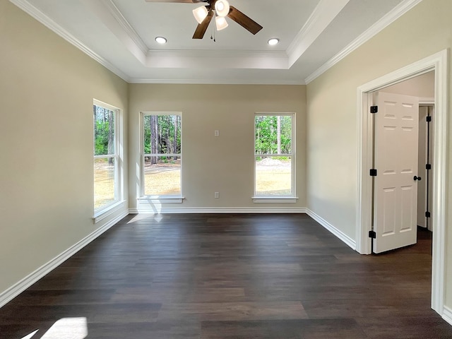 empty room featuring baseboards, a ceiling fan, a tray ceiling, and dark wood-style floors