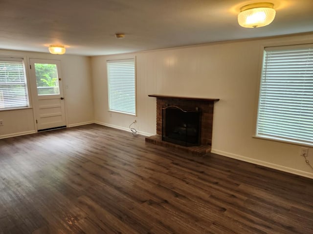 911 Allendale, Lufkin, TX 75904 - unfurnished living room with a brick fireplace and dark wood-type flooring