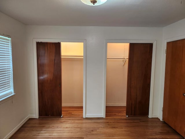 911 Allendale, Lufkin, TX 75904 - unfurnished bedroom with wood finished floors and two closets