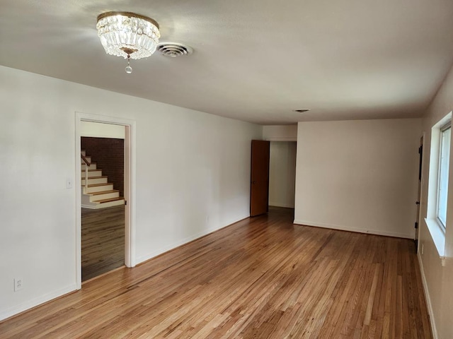 911 Allendale, Lufkin, TX 75904 - unfurnished room featuring light wood-style flooring, stairs, and a chandelier