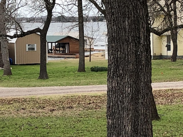 view of yard featuring a shed and a water view