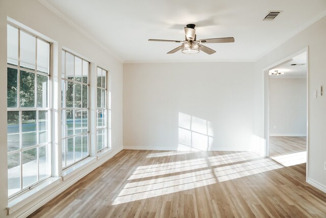 unfurnished room featuring light hardwood / wood-style flooring, a wealth of natural light, and crown molding