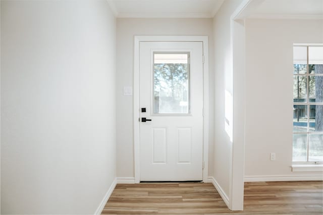 entryway with light wood-type flooring and ornamental molding