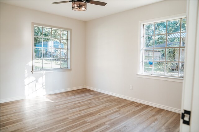 empty room featuring light hardwood / wood-style flooring, a wealth of natural light, and ceiling fan