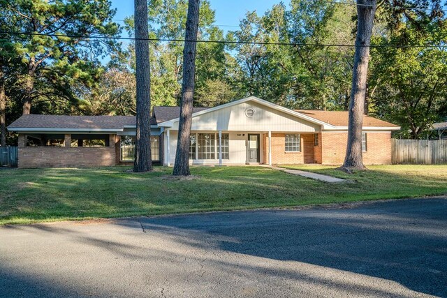 ranch-style house featuring covered porch and a front lawn