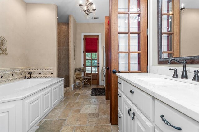 102 Harmony Hill Ct, Lufkin, TX 75901 - full bathroom featuring stone tile flooring, a chandelier, vanity, a garden tub, and a shower