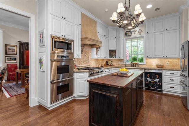 102 Harmony Hill Ct, Lufkin, TX 75901 - kitchen with butcher block countertops, stainless steel appliances, a sink, white cabinetry, and ornamental molding