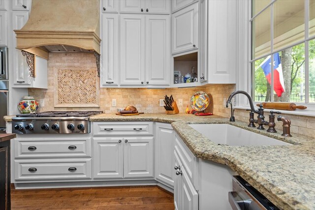 102 Harmony Hill Ct, Lufkin, TX 75901 - kitchen featuring a sink, appliances with stainless steel finishes, white cabinetry, premium range hood, and tasteful backsplash