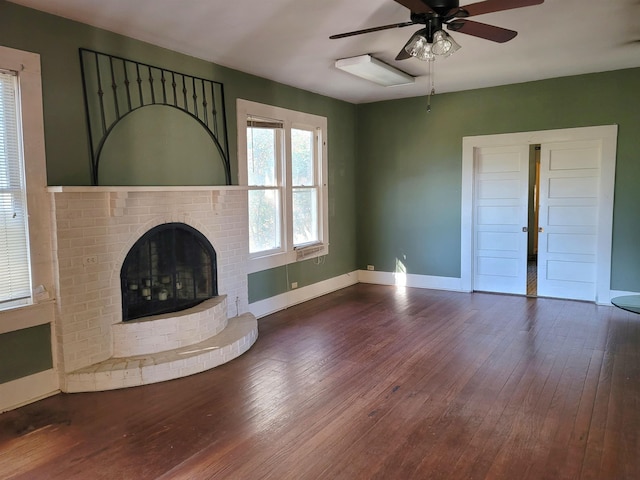 unfurnished living room featuring dark hardwood / wood-style floors, a brick fireplace, and ceiling fan