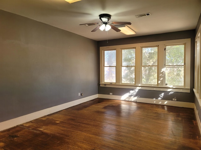 unfurnished room with ceiling fan and dark wood-type flooring