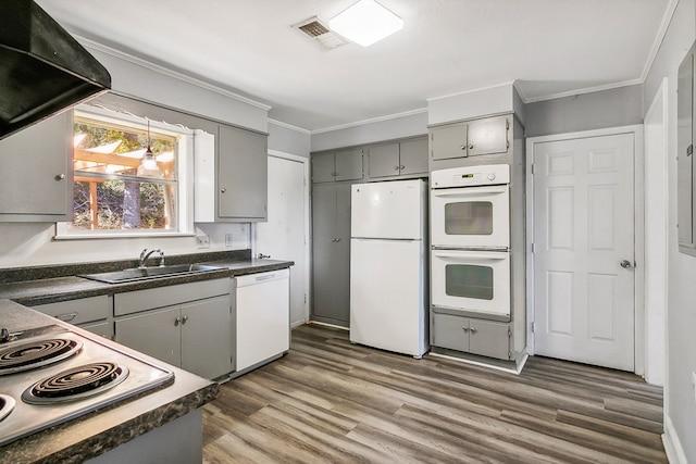 kitchen featuring a sink, white appliances, dark countertops, and gray cabinets