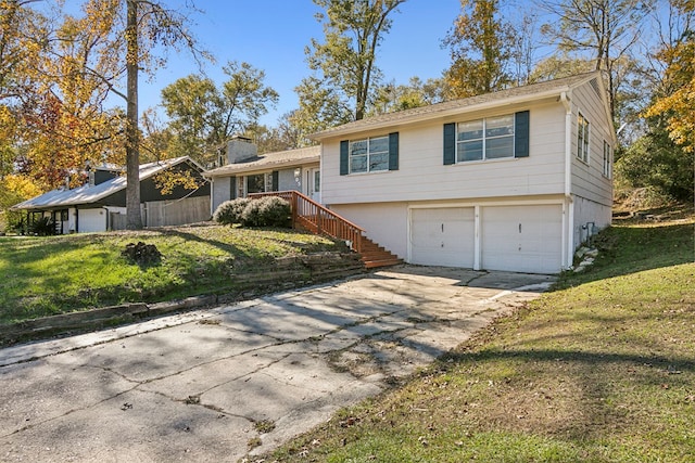 tri-level home with stairs, driveway, a front lawn, and an attached garage