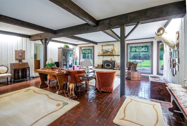 living room with plenty of natural light, beam ceiling, a wood stove, and french doors