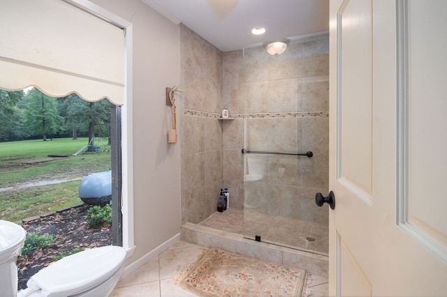 bathroom with tiled shower, tile patterned floors, and toilet