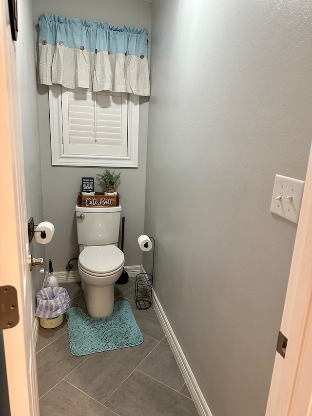 bathroom with toilet and tile patterned floors