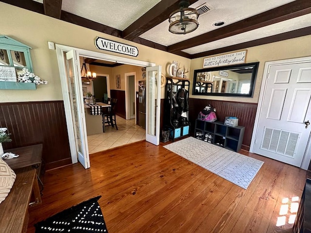 661 N Bowie St, Jasper, TX 75951 - entrance foyer featuring beamed ceiling, a chandelier, a wainscoted wall, wood finished floors, and a textured ceiling