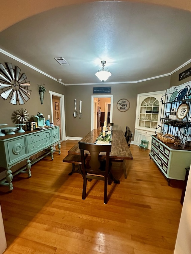 dining room featuring hardwood / wood-style floors and ornamental molding