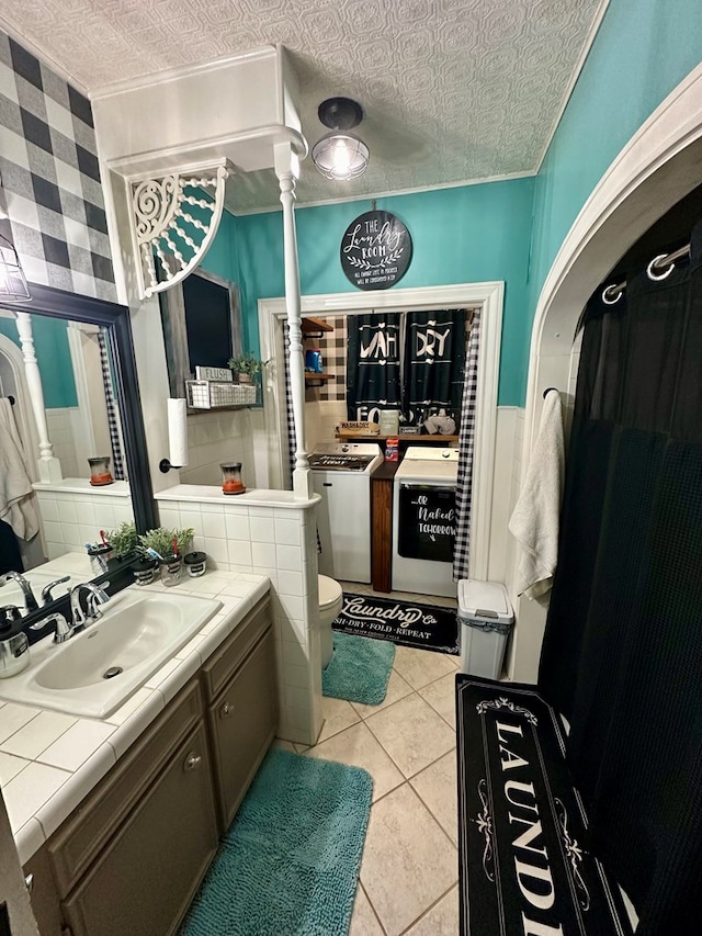 bathroom with toilet, a textured ceiling, washer / clothes dryer, and tile patterned floors