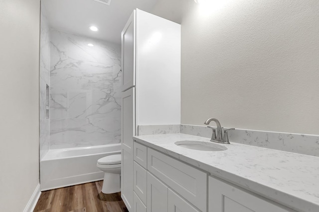 full bathroom with wood-type flooring, vanity, toilet, and tiled shower / bath combo