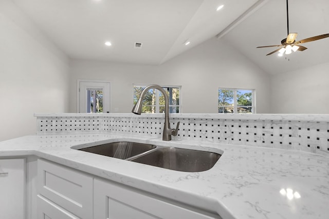 kitchen with plenty of natural light, sink, white cabinets, and lofted ceiling