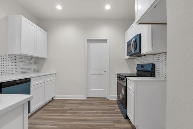 kitchen with backsplash, white cabinetry, black electric range oven, and light wood-type flooring