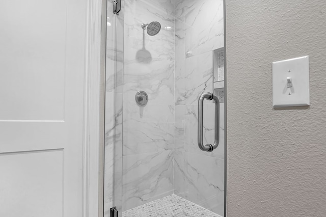 bathroom featuring a shower with door