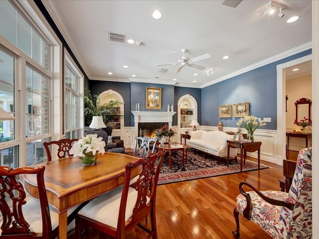 dining room with crown molding, ceiling fan, and wood-type flooring