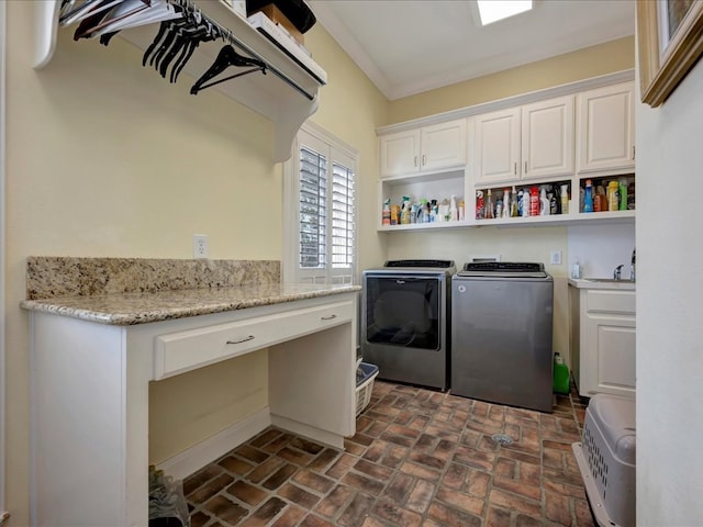 laundry area with washing machine and dryer, crown molding, and cabinets