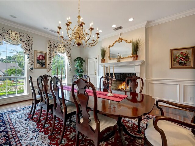 dining area with hardwood / wood-style floors, crown molding, and a chandelier