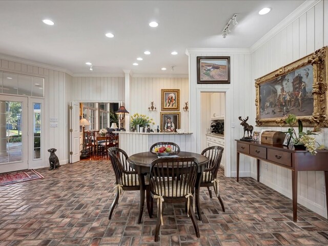 dining area featuring crown molding and wood walls