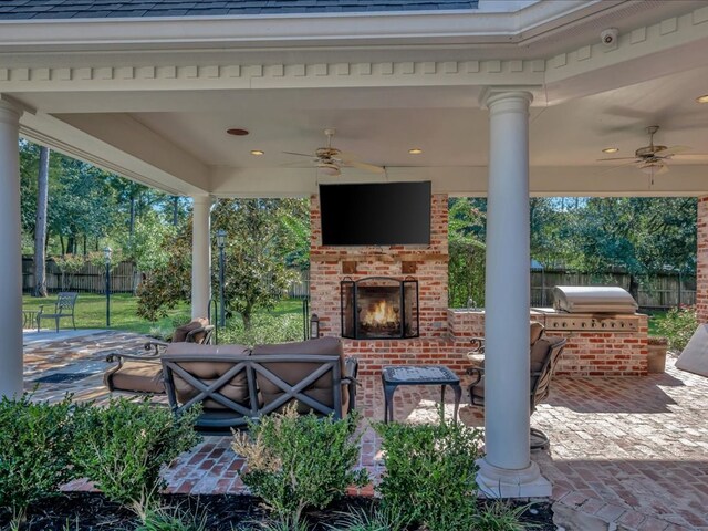 view of patio with an outdoor kitchen, an outdoor brick fireplace, ceiling fan, and a grill