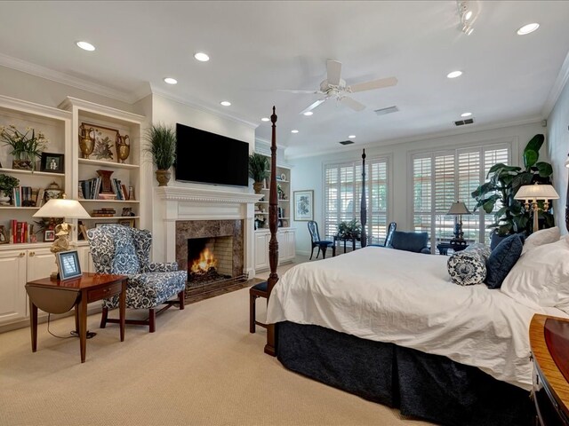 carpeted bedroom featuring a high end fireplace, ceiling fan, and crown molding