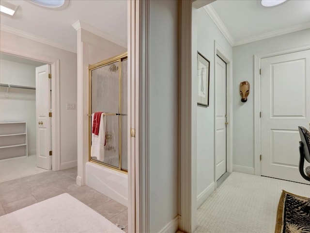 bathroom with tile patterned flooring, crown molding, and bath / shower combo with glass door