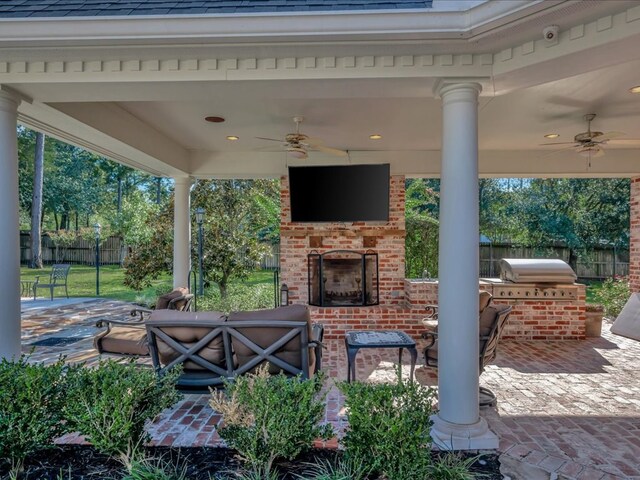 view of patio featuring an outdoor brick fireplace, ceiling fan, exterior kitchen, and grilling area