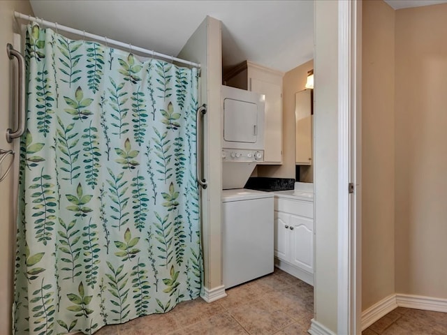 bathroom with stacked washer / dryer, tile patterned flooring, and vanity