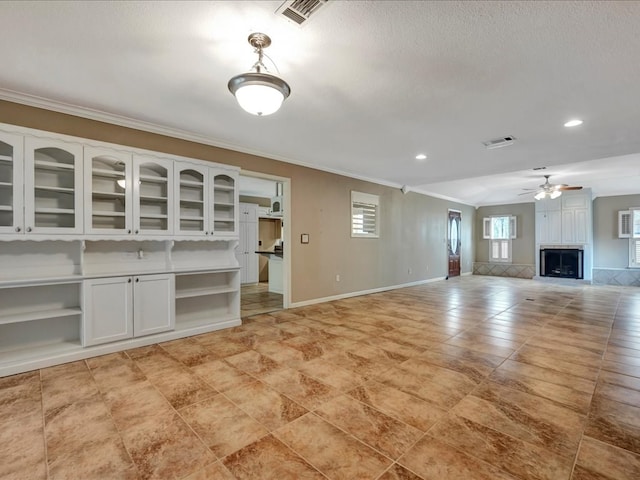 unfurnished living room with crown molding, ceiling fan, a textured ceiling, and light tile patterned floors