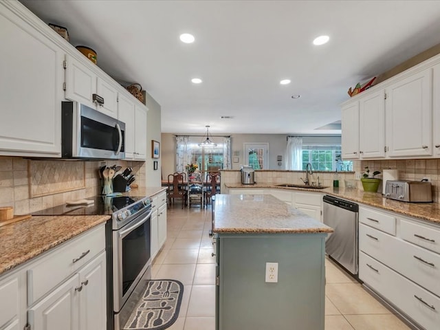 kitchen with a center island, sink, white cabinetry, and stainless steel appliances