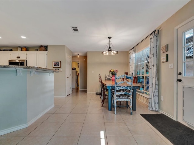 tiled dining room featuring a chandelier