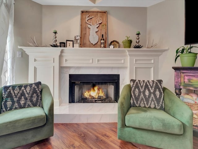 living area featuring hardwood / wood-style flooring and a tile fireplace