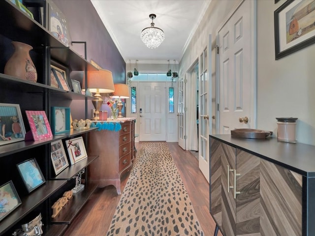 corridor with a chandelier, ornamental molding, and hardwood / wood-style flooring