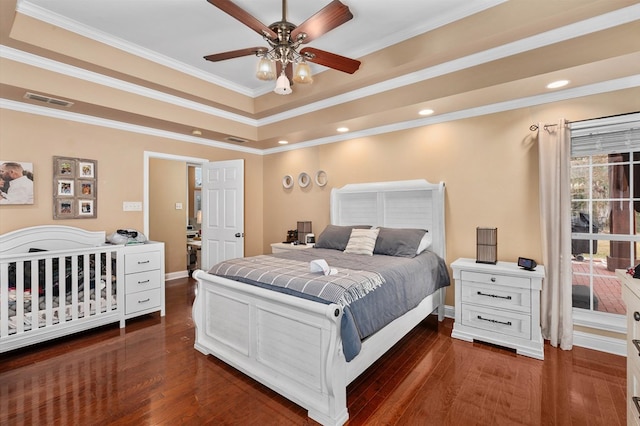 bedroom featuring a raised ceiling, crown molding, dark wood-type flooring, and ceiling fan