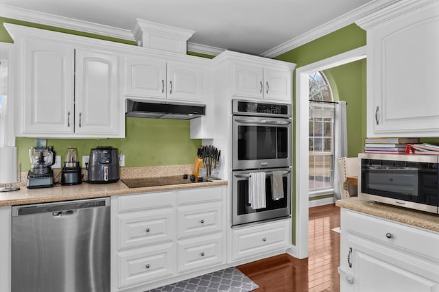 kitchen featuring ornamental molding, appliances with stainless steel finishes, white cabinets, and dark hardwood / wood-style flooring