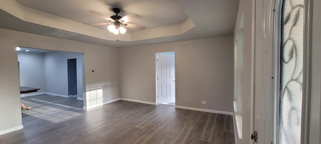 110 Hines St, Diboll, TX 75941 - spare room featuring ceiling fan, a tray ceiling, and dark wood-style flooring