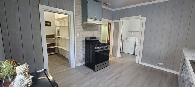 110 Hines St, Diboll, TX 75941 - kitchen with gas range, under cabinet range hood, light wood-type flooring, washer and dryer, and crown molding