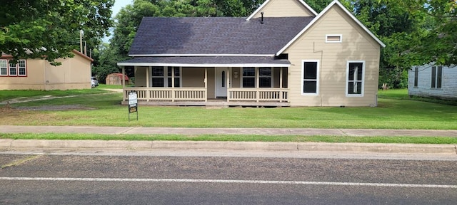 110 Hines St, Diboll, TX 75941 - view of front of house featuring a porch, a front yard, a storage unit, and roof with shingles
