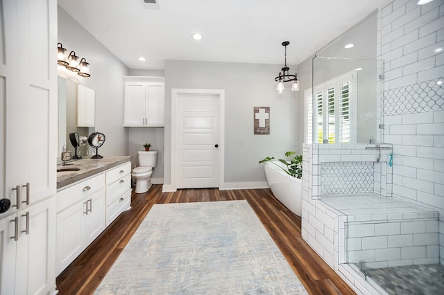 1208 Leslie Ln, Lufkin, TX 75901 - bathroom featuring vanity, tiled shower, a soaking tub, wood finished floors, and a chandelier