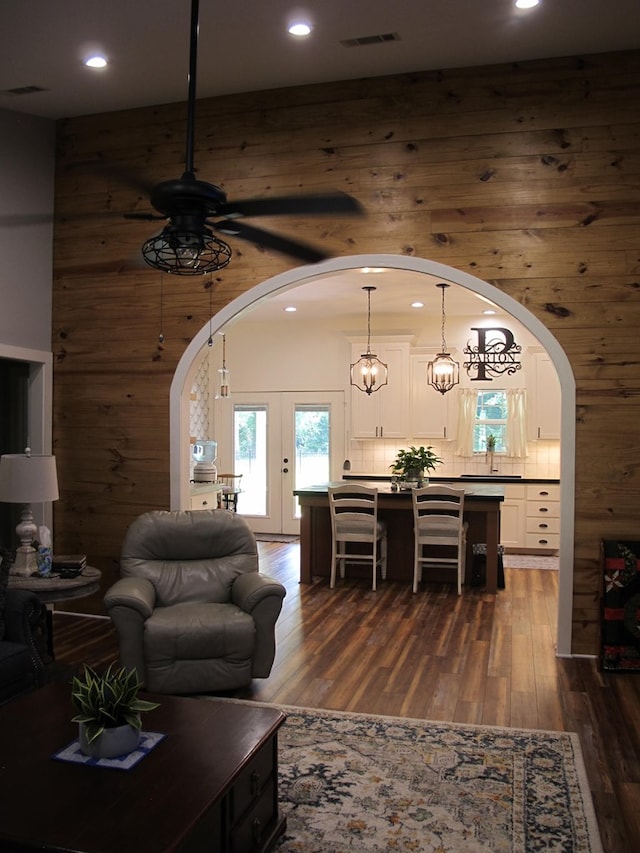 1208 Leslie Ln, Lufkin, TX 75901 - living room featuring arched walkways, ceiling fan, dark wood finished floors, recessed lighting, and wood walls