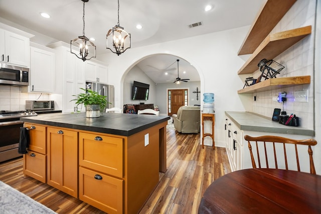 1208 Leslie Ln, Lufkin, TX 75901 - kitchen with appliances with stainless steel finishes, arched walkways, a ceiling fan, decorative backsplash, and dark countertops