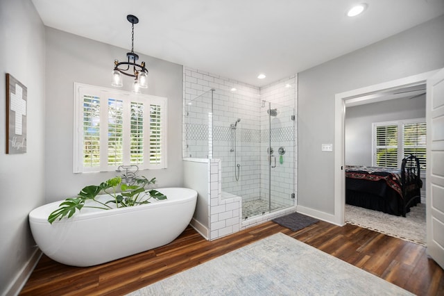 1208 Leslie Ln, Lufkin, TX 75901 - ensuite bathroom featuring a shower stall, a freestanding tub, wood finished floors, a chandelier, and recessed lighting